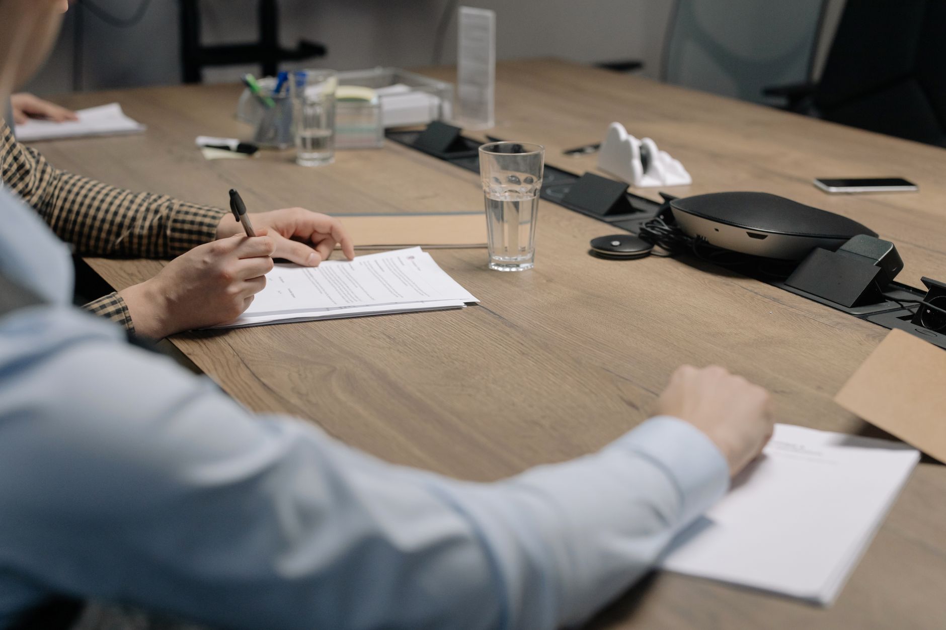 Legal contracts on high-end wooden table with signature pen